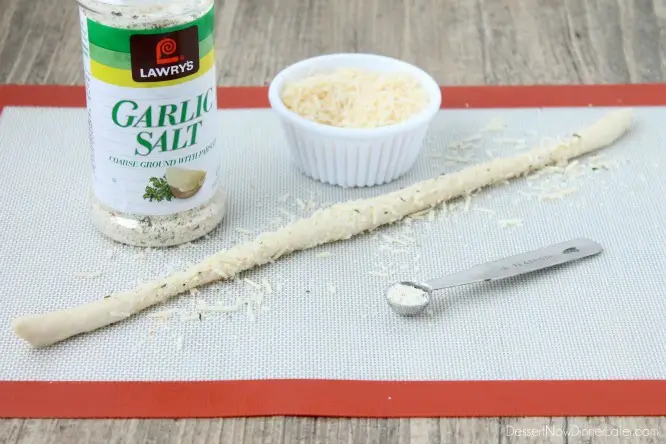Dough rolled into a stick with parmesan and garlic salt adhering to the outside.