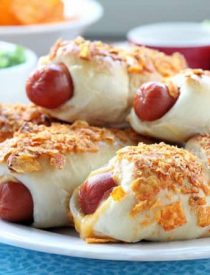 Frozen dough, nacho tortilla chips, and extra cheese transform ordinary pigs in a blanket into these extraordinary crunchy nacho dogs.