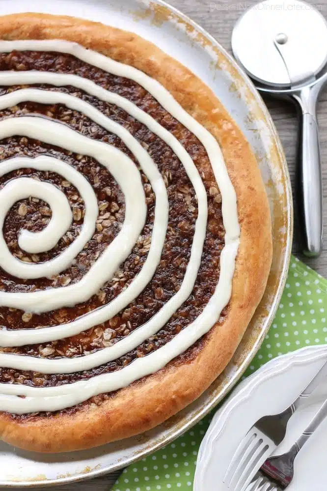 This Cinnamon Roll Dessert Pizza is an amazing copycat version of Papa Murphy's Cinnamon Wheel, with brown sugar, cinnamon, and oats, topped with a tangy cream cheese icing.