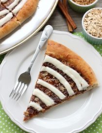 This Cinnamon Roll Dessert Pizza is an amazing copycat version of Papa Murphy's Cinnamon Wheel, with brown sugar, cinnamon, and oats, topped with a tangy cream cheese icing.