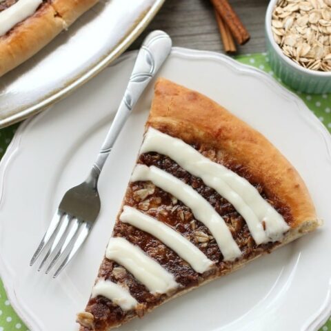 This Cinnamon Roll Dessert Pizza is an amazing copycat version of Papa Murphy's Cinnamon Wheel, with brown sugar, cinnamon, and oats, topped with a tangy cream cheese icing.