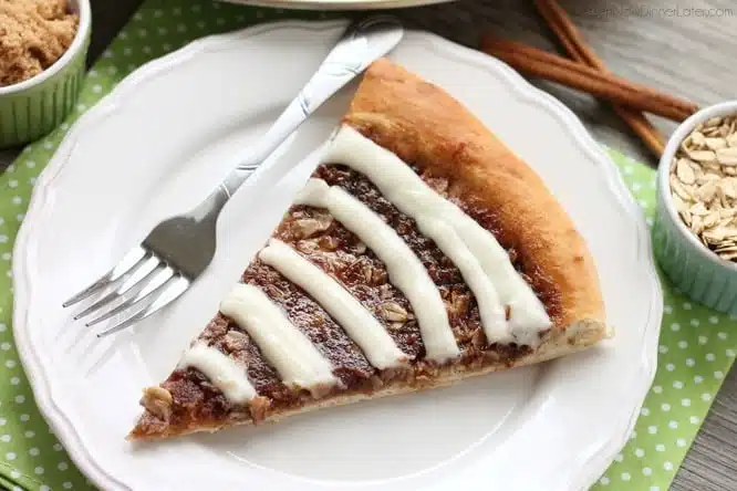 This Cinnamon Roll Dessert Pizza is an amazing copycat version of Papa Murphy's Cinnamon Wheel, with brown sugar, cinnamon, and oats, topped with a tangy cream cheese icing.