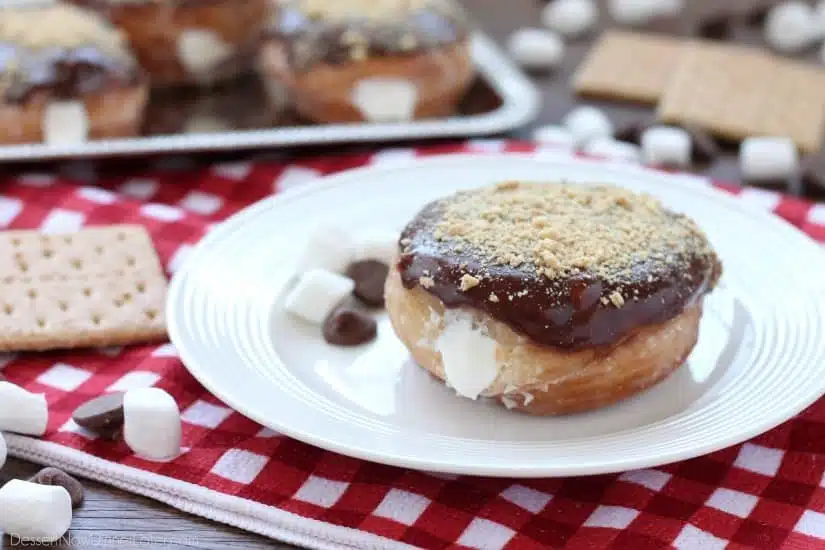 Glazed and ganached, with crushed graham crackers on top, and a marshmallow buttercream center, these S'mores Donuts are delicious and decadent.