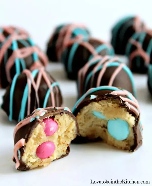 Reveal your baby's gender by putting pink or blue M&M's inside these cookie dough truffles. Image from Love To Be In The Kitchen.