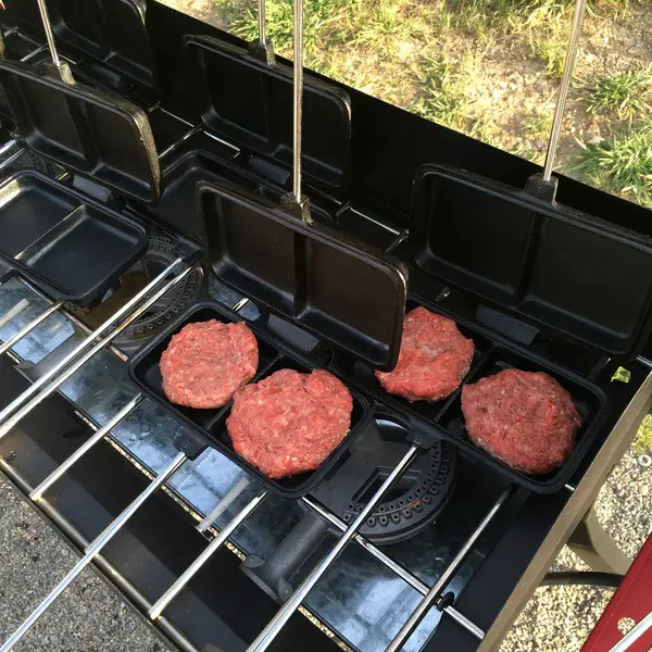 Grilling burgers in dual Camp Chef pie irons.