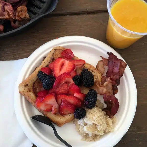 French Toast with fruit, brown sugar grits, and bacon.