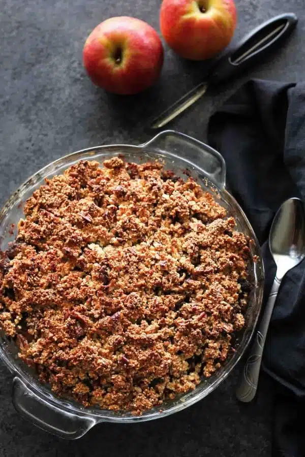 This simple and delicious gluten-free apple crisp is lightly sweet, with a warm hint of cinnamon, and a crunchy nut topping!