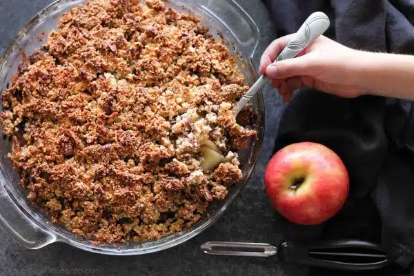 This simple and delicious gluten-free apple crisp is lightly sweet, with a warm hint of cinnamon, and a crunchy nut topping!