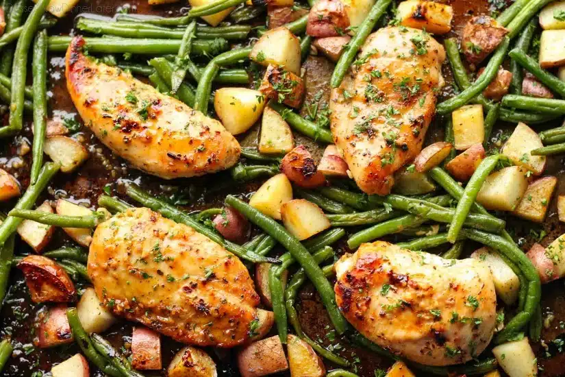 This one pan chicken dinner has the most delicious honey garlic glazed chicken alongside tenderly roasted potatoes and green beans. Plus, it's so easy and flavorful, you'll make again and again!