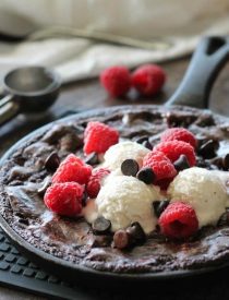 This fudgy skillet brownie is made with a boxed mix for a quick dessert for two! Eat it warm from the oven topped with ice cream, chocolate chips, and fresh raspberries for an extra special treat!