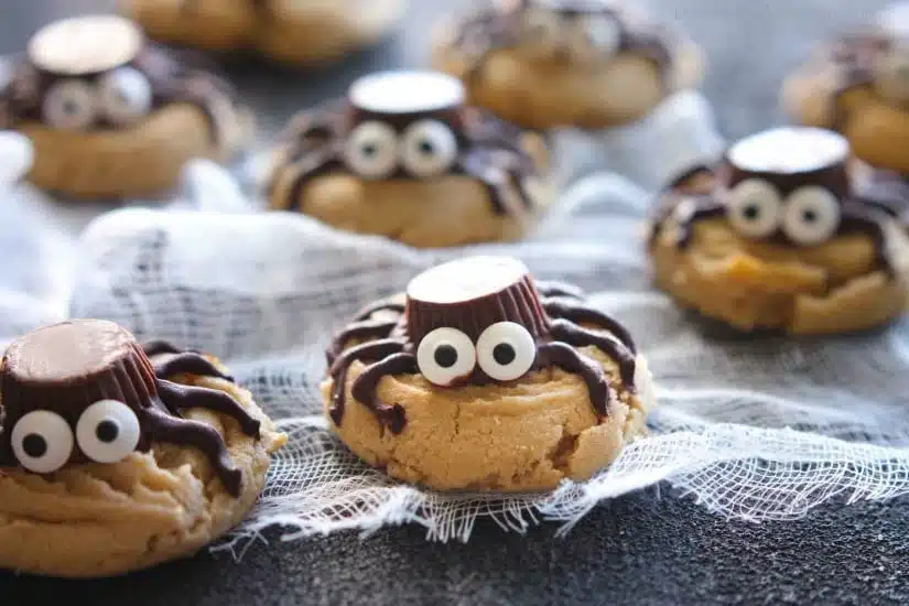 Not all Halloween food has to be gross and gory! These super cute spider cookies are made with peanut butter cups, chocolate, candy eyes, and the BEST peanut butter cookie recipe you'll ever try!