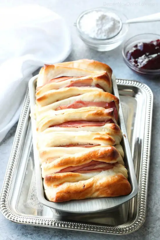 This Monte Cristo Pull Apart Bread is full of savory meats and melty cheese. It's topped with a dusting of powdered sugar and served with raspberry preserves. Works great as a breakfast, lunch, dinner, or appetizer!