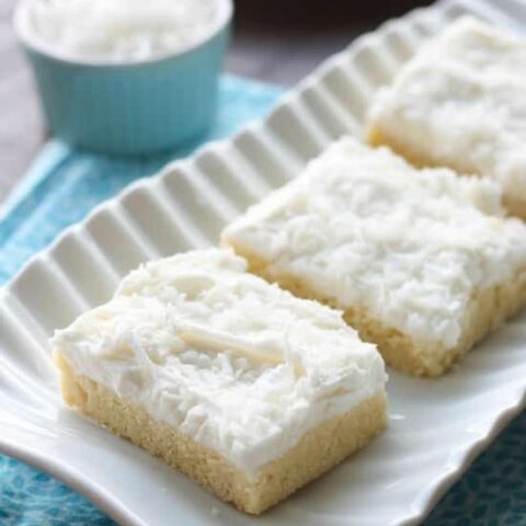 These Coconut Sugar Cookie Bars have lots of delicious coconut flavor from the crust, to the frosting, and the shredded coconut on top. Plus, they are super soft, chewy, and easy to make!