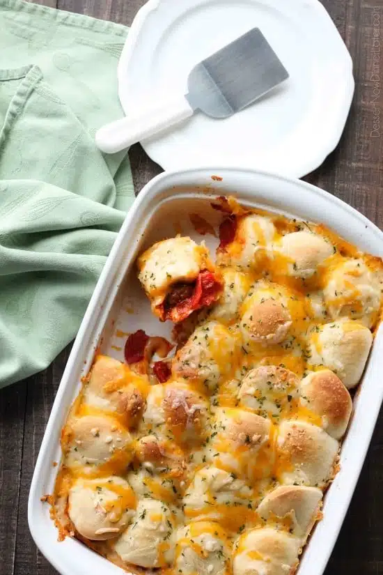 This deep dish casserole is a meatball sandwich and pizza in one! Saucy meatballs and pieces of pepperoni are sandwiched between fresh bread and topped with cheese for a hearty dinner, party appetizer, or sports game snack.