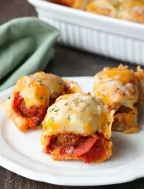 This deep dish casserole is a meatball sandwich and pizza in one! Saucy meatballs and pieces of pepperoni are sandwiched between fresh bread and topped with cheese for a hearty dinner, party appetizer, or sports game snack.