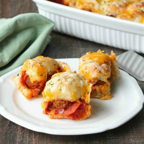 This deep dish casserole is a meatball sandwich and pizza in one! Saucy meatballs and pieces of pepperoni are sandwiched between fresh bread and topped with cheese for a hearty dinner, party appetizer, or sports game snack.