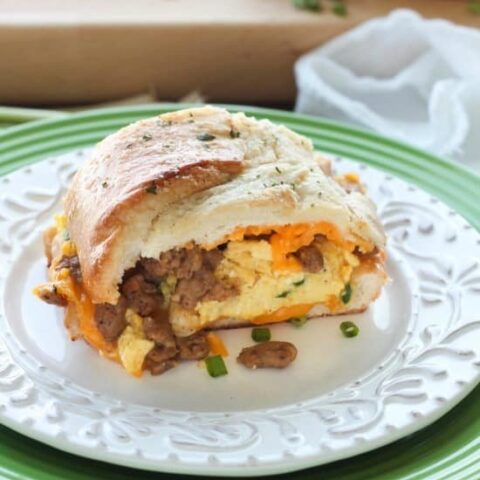 This Breakfast Stuffed French Bread is like a huge breakfast sandwich stuffed with soft scrambled eggs, meaty sausage, and sharp cheddar cheese inside a fresh baked loaf of French bread. (Substitute your favorite meats or cheeses to create your own!)