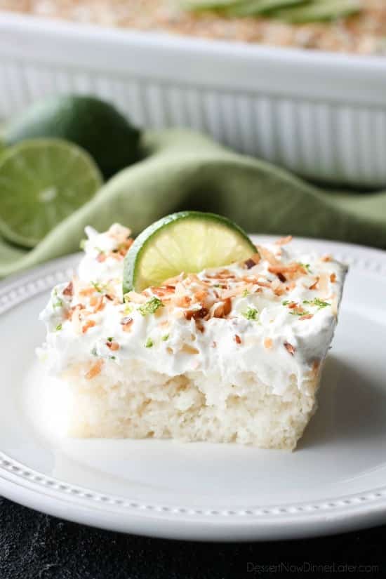 Coconut Lime Poke Cake - a fluffy, white, lime-infused cake that is soaked with coconut cream, and topped with sweetened whipped cream, toasted coconut, and lime zest. It's super moist and full of tropical flavors!