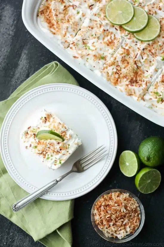 Coconut Lime Poke Cake - a fluffy, white, lime-infused cake that is soaked with coconut cream, and topped with sweetened whipped cream, toasted coconut, and lime zest. It's super moist and full of tropical flavors!