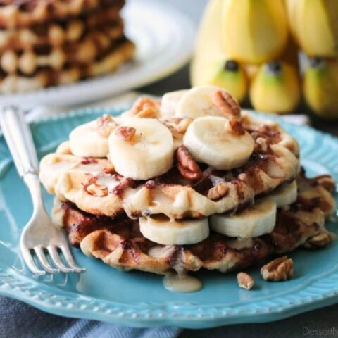 Cinnamon Roll Waffles are topped with freshly sliced bananas, crunchy nuts, and a maple cream cheese drizzle.