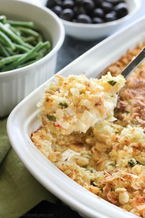 These funeral potatoes are creamy and cheesy, with sour cream, onions, extra spices, and a crunchy potato chip topping. Always a hit, this cheesy potato casserole will get gobbled up quick! Great for potlucks and holidays.