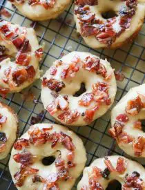 Maple Bacon Donuts are breakfast perfection! The salty bacon cuts through the sweetness of the maple and brown sugar glaze on top of a fluffy yeast donut.