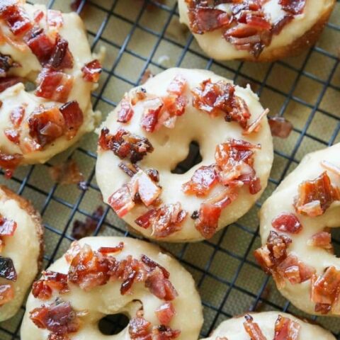 Maple Bacon Donuts are breakfast perfection! The salty bacon cuts through the sweetness of the maple and brown sugar glaze on top of a fluffy yeast donut.