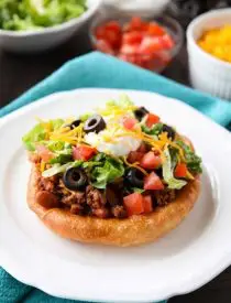 These easy Navajo Tacos (also known as Indian Fry Bread) are quick to whip up for dinner, smothered with a beef and bean taco filling, and finished with all the classic taco toppings. A fair food favorite made easily at home!