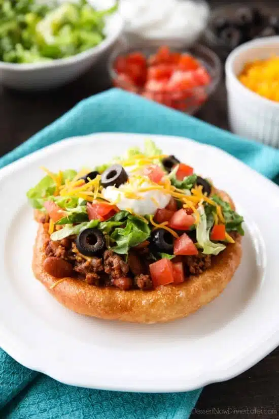 These easy Navajo Tacos (also known as Indian Fry Bread) are quick to whip up for dinner, smothered with a beef and bean taco filling, and finished with all the classic taco toppings. A fair food favorite made easily at home!