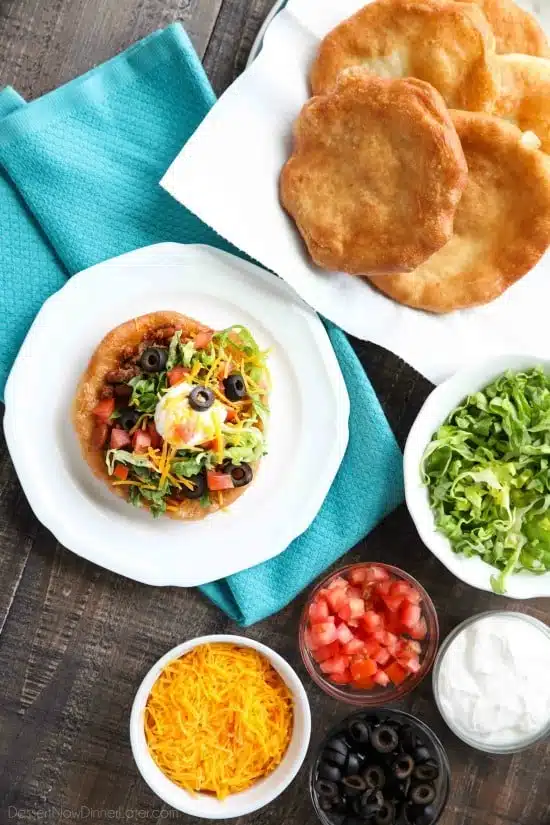 These easy Navajo Tacos (also known as Indian Fry Bread) are quick to whip up for dinner, smothered with a beef and bean taco filling, and finished with all the classic taco toppings. A fair food favorite made easily at home!