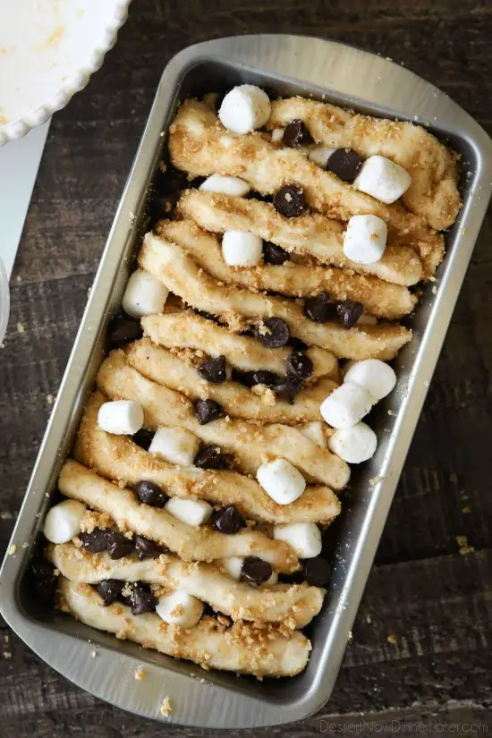 S'mores Pull Apart Bread is loaded with graham cracker crumbs, marshmallows, and chocolate chips, then topped off with a marshmallow glaze for a camping inspired dessert you can enjoy anytime!