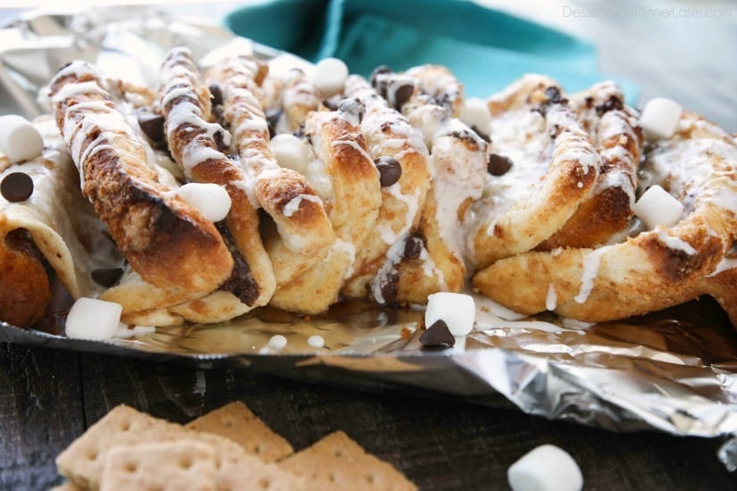 S'mores Pull Apart Bread is loaded with graham cracker crumbs, marshmallows, and chocolate chips, then topped off with a marshmallow glaze for a camping inspired dessert you can enjoy anytime!