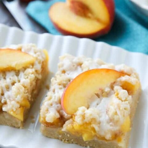 These Peach Crumb Bars are made with fresh summer peaches, sandwiched between a sweet buttery crust and crumb topping, with a hint of cinnamon, and are drizzled with a fresh almond (or vanilla) glaze. The most delicious summer dessert!