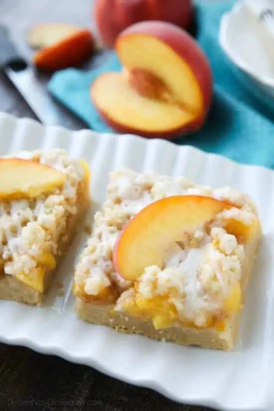 These Peach Crumb Bars are made with fresh summer peaches, sandwiched between a sweet buttery crust and crumb topping, with a hint of cinnamon, and are drizzled with a fresh almond (or vanilla) glaze. The most delicious summer dessert!