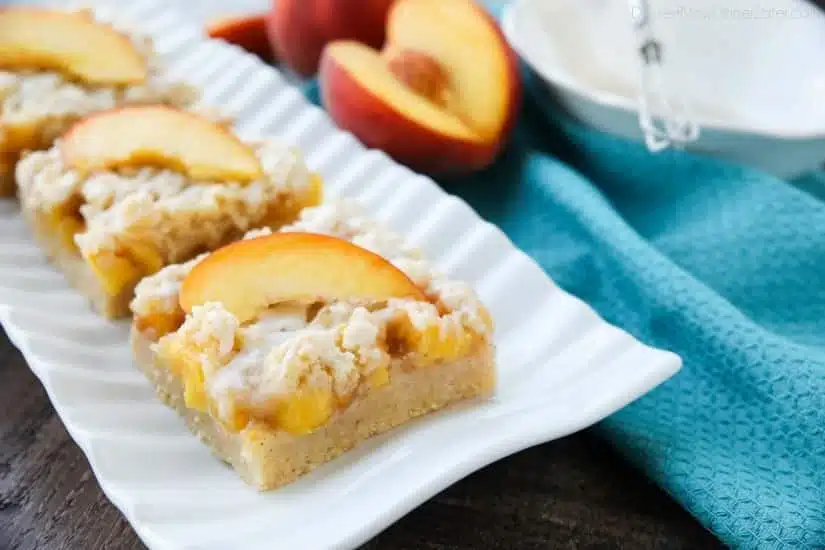 These Peach Crumb Bars are made with fresh summer peaches, sandwiched between a sweet buttery crust and crumb topping, with a hint of cinnamon, and are drizzled with a fresh almond (or vanilla) glaze. The most delicious summer dessert!