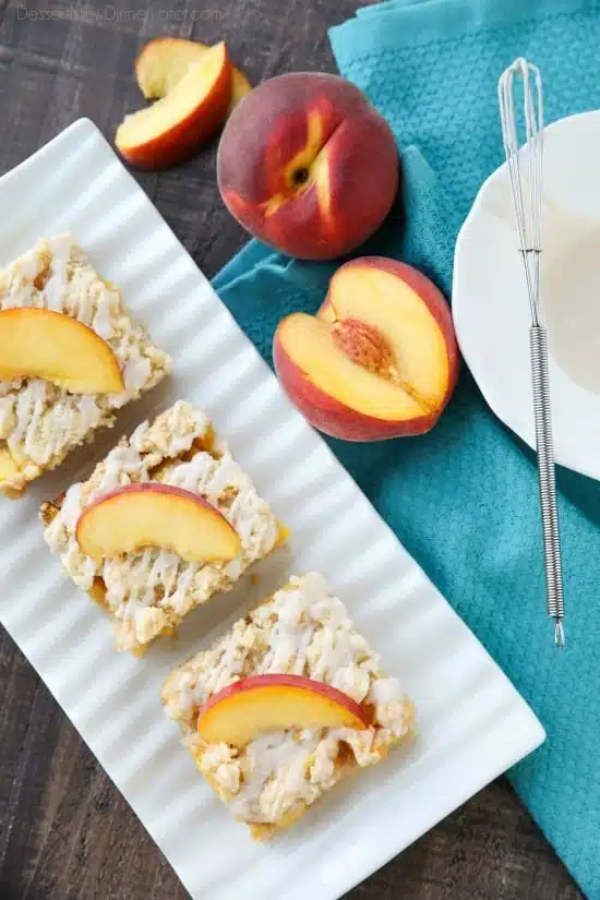 These Peach Crumb Bars are made with fresh summer peaches, sandwiched between a sweet buttery crust and crumb topping, with a hint of cinnamon, and are drizzled with a fresh almond (or vanilla) glaze. The most delicious summer dessert!