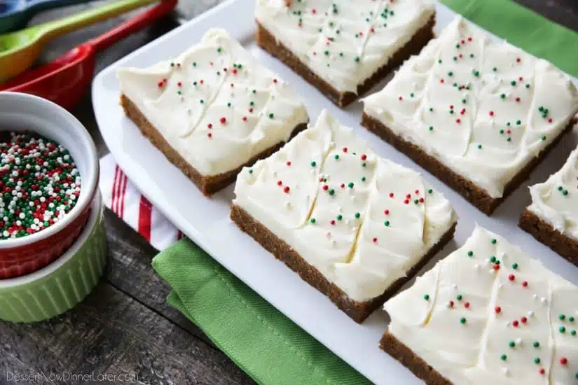 Gingerbread Cookie Bars have a soft and chewy, spiced molasses cookie base topped with the BEST cream cheese frosting. Add red and green sprinkles or nonpareils for a festive Christmas dessert!