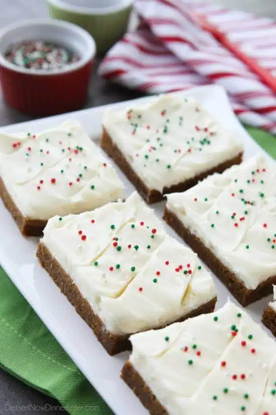 Gingerbread Cookie Bars have a soft and chewy, spiced molasses cookie base topped with the BEST cream cheese frosting. Add red and green sprinkles or nonpareils for a festive Christmas dessert!