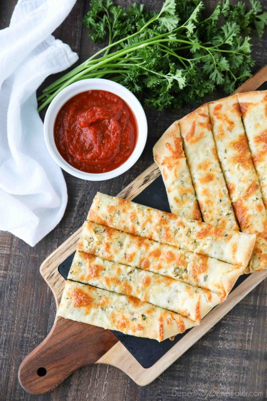 These easy Cheesy Garlic Breadsticks are loaded with garlic, cheese, and herbs for a great tasting breadstick to enjoy for pizza night. Also delicious dipped in marinara sauce!