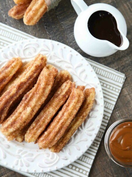 This churros recipe is super easy to make with a simple churro dough that is piped into oil and fried, then coated in cinnamon-sugar. You can enjoy these crisp, yet soft homemade churros anytime!