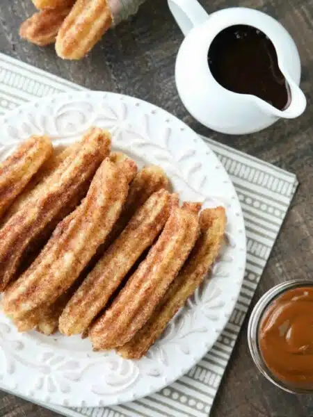 This churros recipe is super easy to make with a simple churro dough that is piped into oil and fried, then coated in cinnamon-sugar. You can enjoy these crisp, yet soft homemade churros anytime!