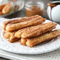 This churros recipe is super easy to make with a simple churro dough that is piped into oil and fried, then coated in cinnamon-sugar. You can enjoy these crisp, yet soft homemade churros anytime!