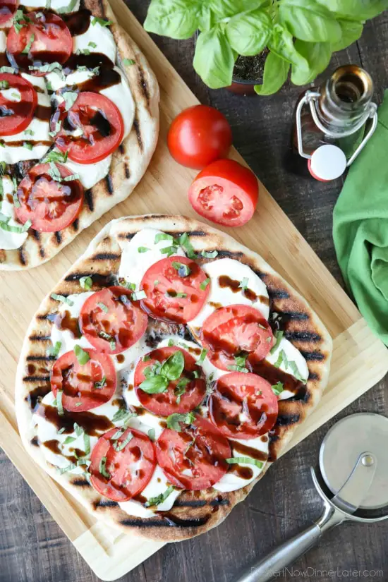 Grilled Caprese Flatbread makes a great summer dinner or appetizer. Freshly grilled bread is topped with mozzarella, tomatoes, basil, and garlic, then drizzled with a simple balsamic glaze. 