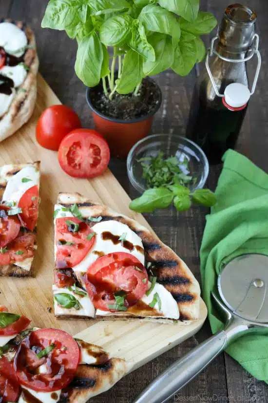 Grilled Caprese Flatbread makes a great summer dinner or appetizer. Freshly grilled bread is topped with mozzarella, tomatoes, basil, and garlic, then drizzled with a simple balsamic glaze. 