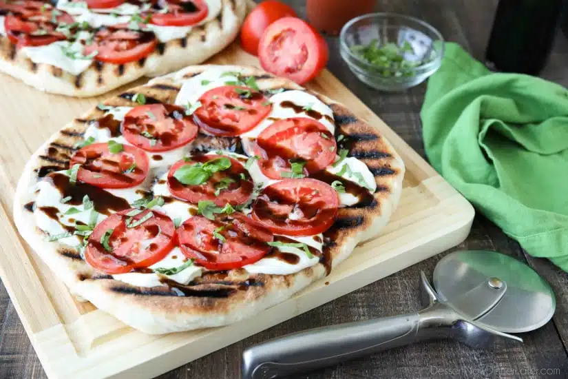 Grilled Caprese Flatbread makes a great summer dinner or appetizer. Freshly grilled bread is topped with mozzarella, tomatoes, basil, and garlic, then drizzled with a simple balsamic glaze. 