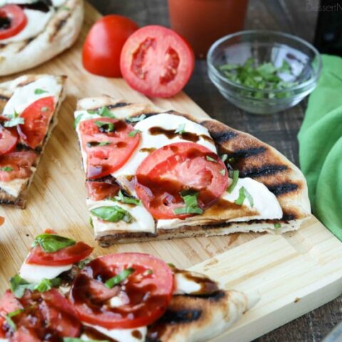 Grilled Caprese Flatbread makes a great summer dinner or appetizer. Freshly grilled bread is topped with mozzarella, tomatoes, basil, and garlic, then drizzled with a simple balsamic glaze. 