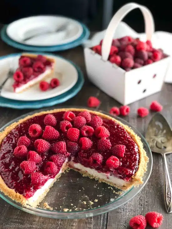 Raspberry Cream Pie with a vanilla wafer crust in a pan with a couple slices taken out.