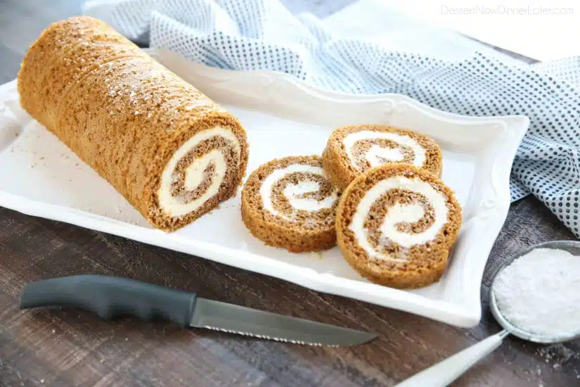 This classic Pumpkin Roll is a simple spiced pumpkin cake rolled up with the BEST cream cheese frosting inside. Use parchment paper for easy rolling -- no towel needed.