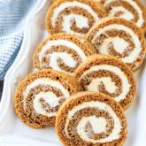 This classic Pumpkin Roll is a simple spiced pumpkin cake rolled up with the BEST cream cheese frosting inside. Use parchment paper for easy rolling -- no towel needed.