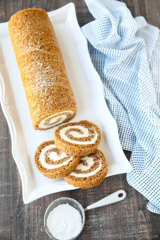 This classic Pumpkin Roll is a simple spiced pumpkin cake rolled up with the BEST cream cheese frosting inside. Use parchment paper for easy rolling -- no towel needed.